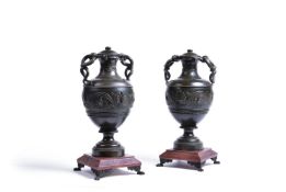 A pair of Continental patinated bronze and rouge marble mounted twin handled urns, late 19th century