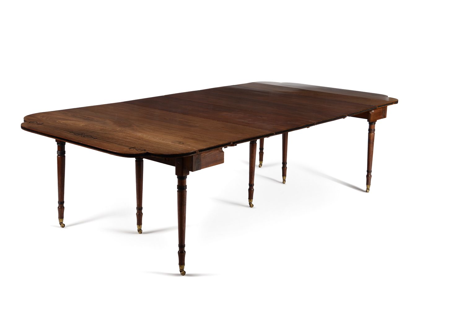 ϒ A Regency mahogany and ebony inlaid concertina action extending dining table, circa 1815