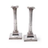 An Edwardian pair of silver Corinthian column candlesticks by Hawksworth, Eyre & Co. Ltd.