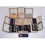 A collection of twelve cased sets of silver and silver coloured spoons