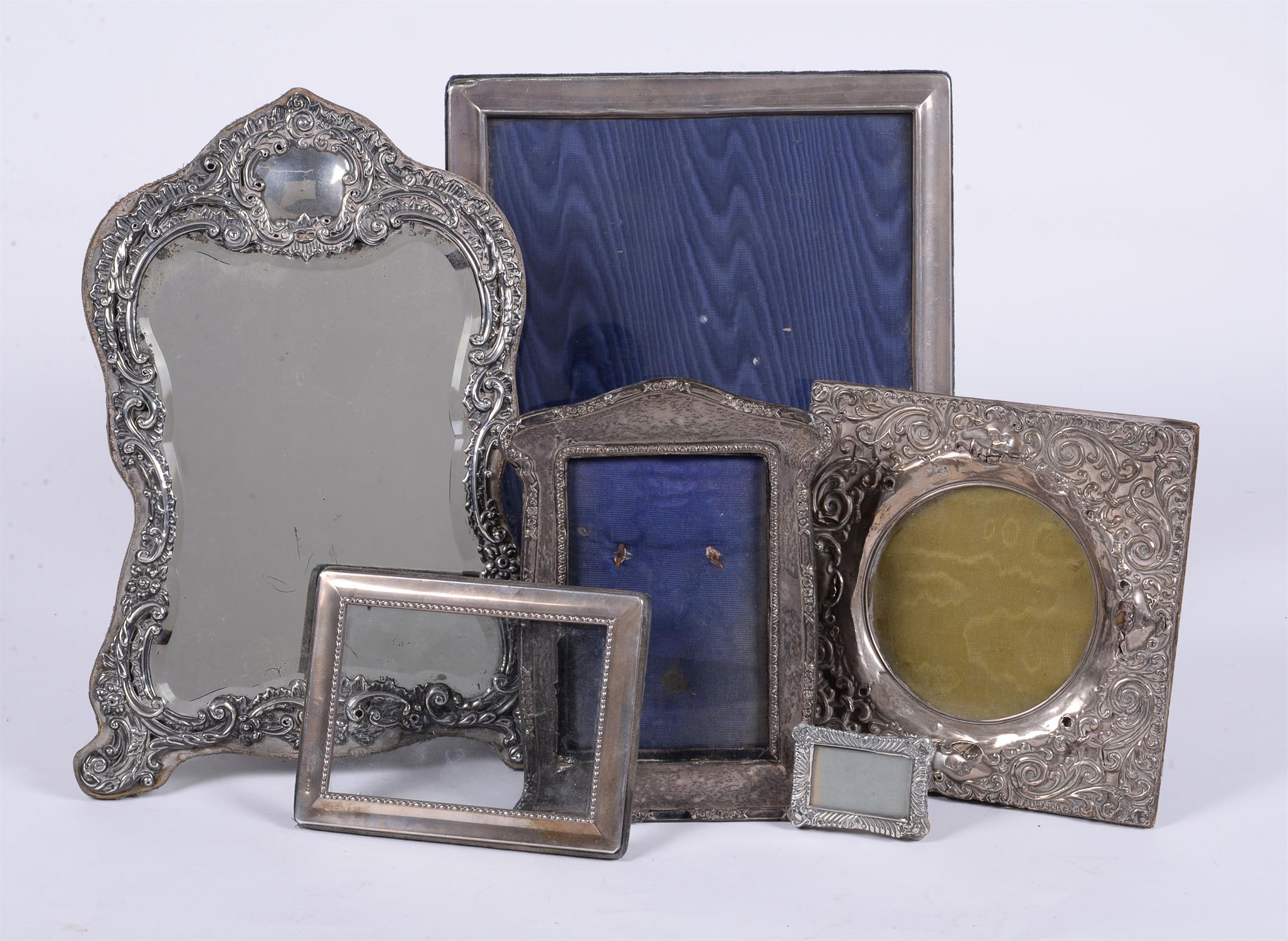 A collection of silver mounted photo frames and a silver mounted mirror