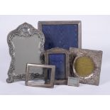 A collection of silver mounted photo frames and a silver mounted mirror