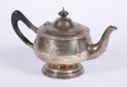 A silver circular tea pot by Walker & Hall