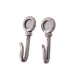 A pair of silver napkin hooks