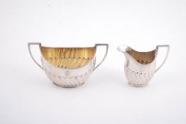 A silver half gadrooned oval sugar bowl and milk jug by Elkington & Co. Ltd.