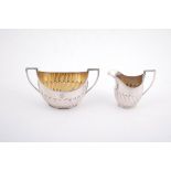 A silver half gadrooned oval sugar bowl and milk jug by Elkington & Co. Ltd.