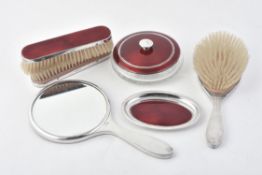 A matched silver mounted and red guilloche enamel dressing table set by Adie Brothers Ltd.