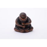 A Wood Netsuke carved in the form of a Tengu