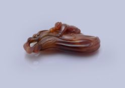 A Chinese carved agate 'Finger citrus and boy' paper weight