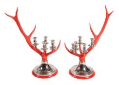 A pair of red painted antler and chromed metal mounted five light candelabra by Anthony Redmile