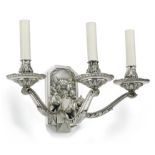 A pair of silver coloured alloy metal three light wall appliqués in Art Deco style