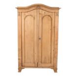 A Continental stripped pine and composition moulding mounted armoire