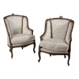 A pair of French carved walnut and upholstered armchairs