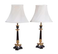 A pair of French gilt and lacquered metal candlesticks in Louis Philippe taste refitted as lamps