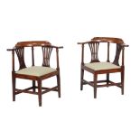 A pair of George III mahogany corner armchairs