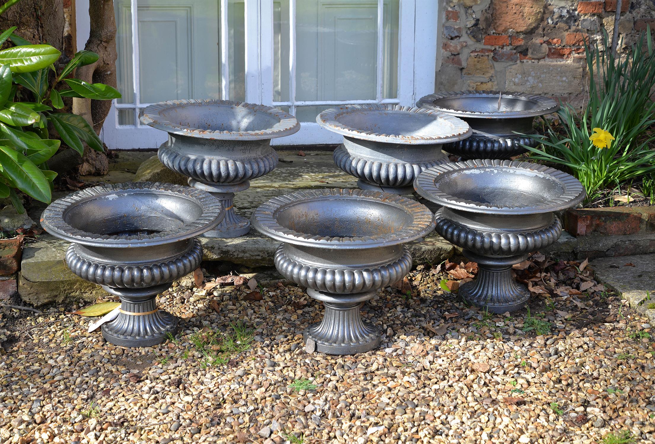 A matched set of six Victorian painted cast iron urns