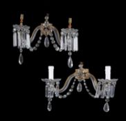 A set of four Victorian cut and moulded glass and gilt metal mounted twin light lustre wall applique