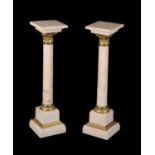 A pair of Continental mottled pink marble and gilt bronze mounted columns