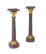 A pair of French porphyritic stone and gilt bronze mounted pedestal columns