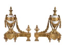 A pair of French gilt bronze and white marble mounted chenets in Louis XVI style