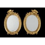 A pair of French carved giltwood oval mirrors