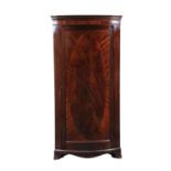 An Edwardian mahogany bowfront corner wardrobe