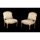 A pair of French carved giltwood low chairs in Louis XV style