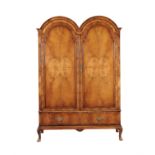 A walnut double domed wardrobe in early 18th century style