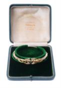 An Edwardian 15 carat gold, sapphire and half pearl bangle