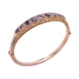 A 9 carat gold garnet hinged bangle