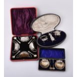 A cased pair of Edwardian silver shell shaped salts and spoons by Mitchell Bosley & Co.