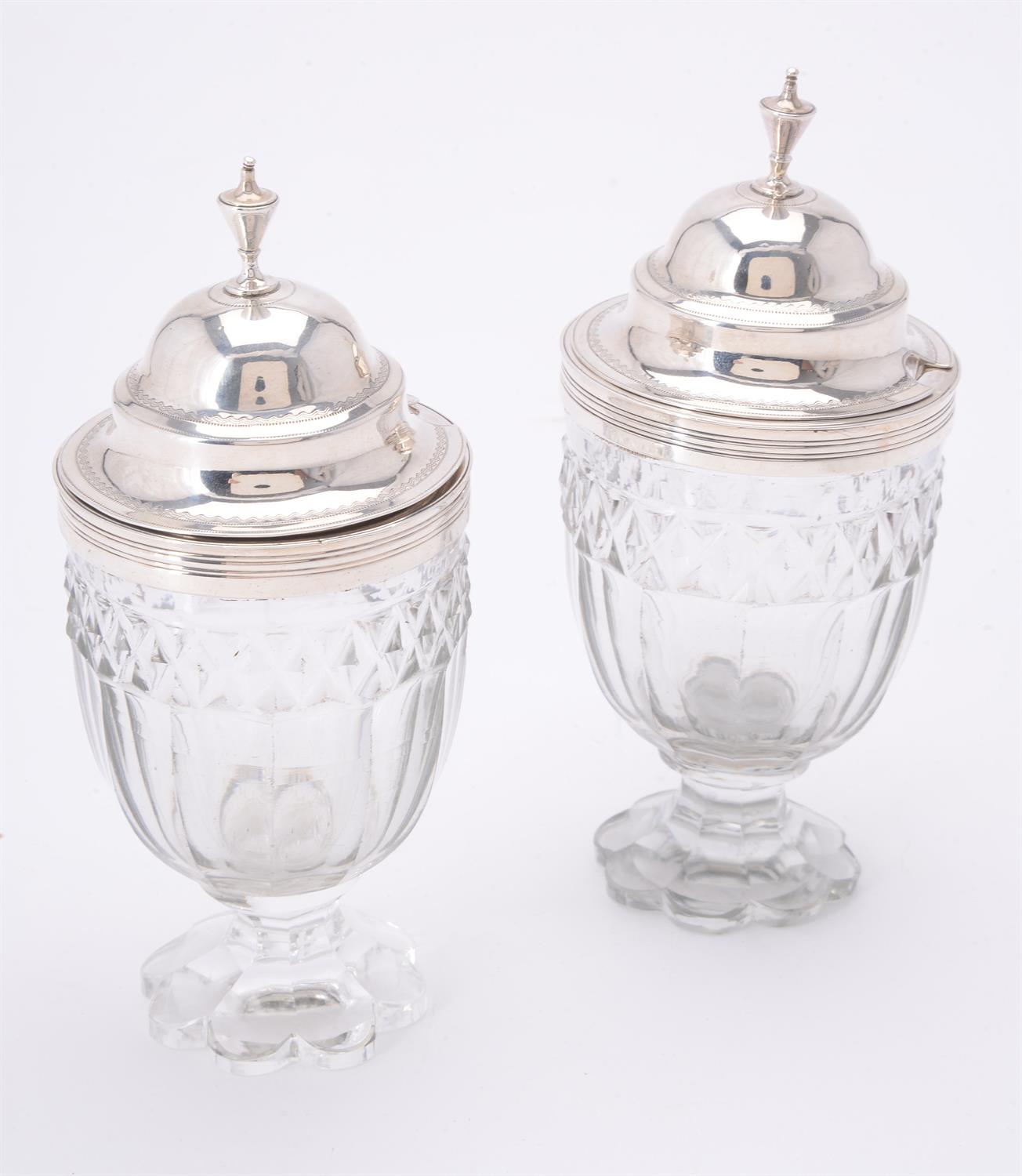 A pair of George III glass mustard jars with silver covers by Charles Chesterman II