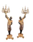 A pair of carved, painted, ebonised and parcel gilt wood blackamoor torcheres