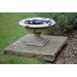 A pair of small white painted cast iron urns on plinths