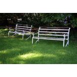 A pair of white painted wrought iron garden benches
