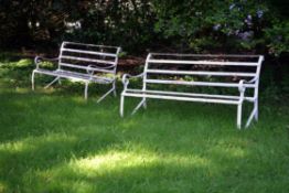 A pair of white painted wrought iron garden benches