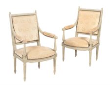 A pair of cream painted armchairs