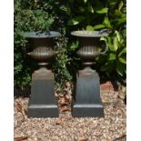 A pair green painted cast iron garden urns