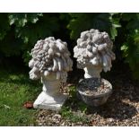 A pair of reconstituted stone finials modelled as fruit and flower vases