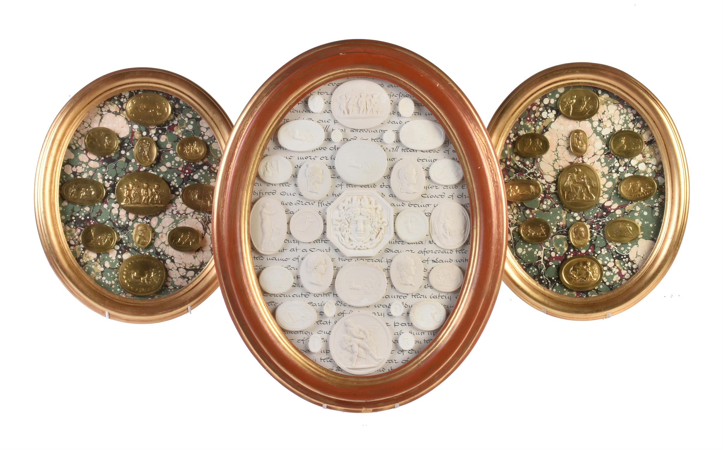 A pair of giltwood framed arrangements of brass intaglio casts after the Antique
