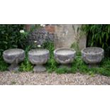 A set of four stone composition garden urns