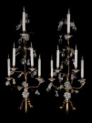 A pair of large brass and clear glass five light wall appliques in Louis XV style