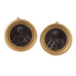 A pair of French patinated bronze relief roundels of nymphs