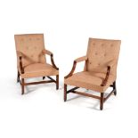A pair of George III mahogany and button upholstered library armchairs