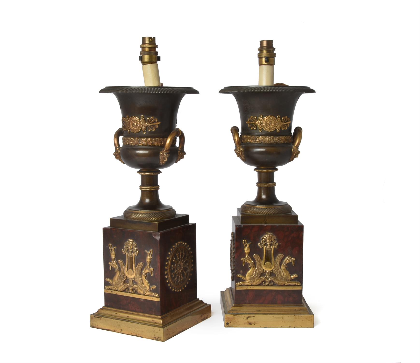 A pair of Empire patinated and parcel gilt bronze and rouge griotte mounted campana urns