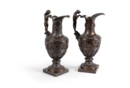 A pair of patinated bronze ewers in the manner of Nicholas Delaunay