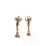 A pair of French gilt metal and marble mounted five light figural candelabra