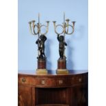 A pair of French gilt and patinated bronze, and rouge griotte mounted figural three light candelabra