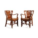 A pair of Victorian walnut and leather upholstered armchairs