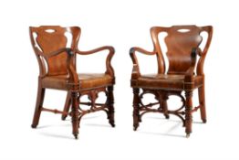 A pair of Victorian walnut and leather upholstered armchairs